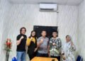 Ketua HIPMI Peduli Sleman dan Kepala Dinas Sosial Sleman berjabat tangan sebagai simbol kerjasama.