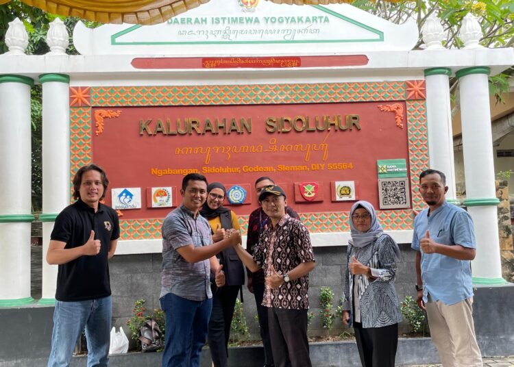 Anggota HIPMI dan warga lokal berpose di depan Kantor Kelurahan Sidoluhur.